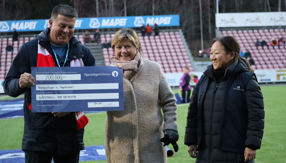 Markedsansvarlig i KIL Toppfotball, Rune Lundgren (t.v.) og Marianne Aspebakken i Kongsvinger Demensforening (midten) er overveldet over støtten som Jannicke S. Mykkestue (t.h.) kunne overrekke på vegne av Gjensidigestiftelsen rett før lørdagens hjemmekamp på Gjemselund.