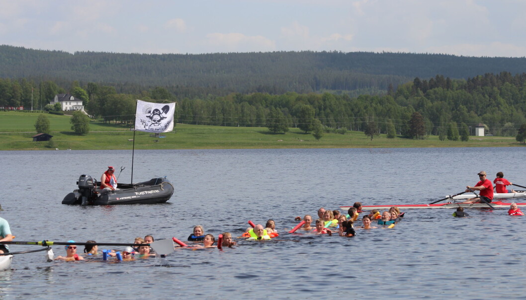Lang rekke med folk ute i vannet samtidig. Lang rekke med folk ute i vannet samtidig.