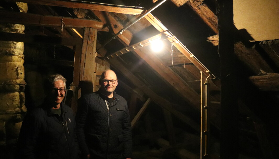 Huseier Ronny Ruud (t.h.) og fagleder Andreas Fuglum inspiserer sprinker-rør på loftet i Ruuds hus i Øvrebyen. I år bruker kommunen og Riksantikvaren til sammen to millioner kroner på slike anlegg i andre bygg i Øvrebyen.